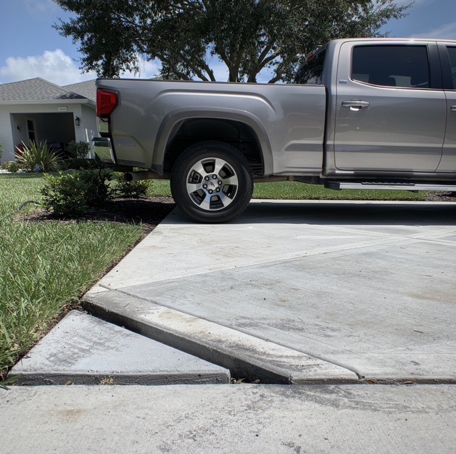 hollow concrete driveway void exposing soil beneath slab