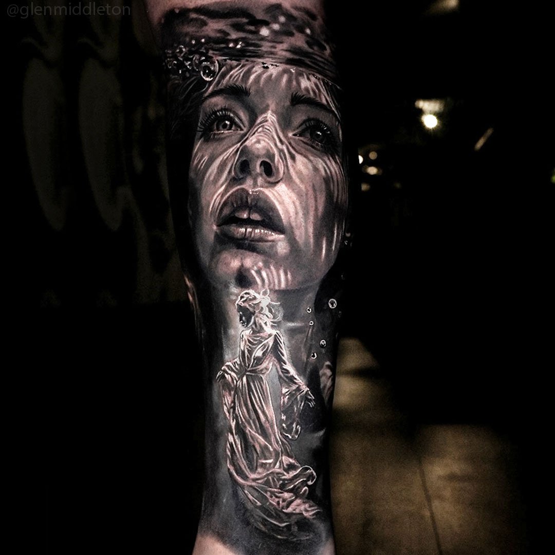 Black and grey forearm tattoo by Glen Middleton featuring a realistic underwater female portrait with flowing light reflections and fine art realism.