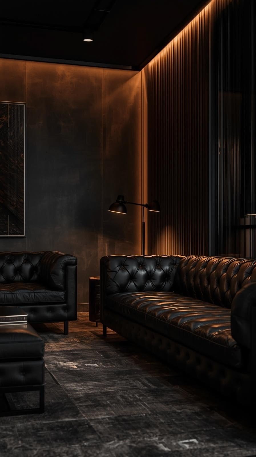 A dark interior room featuring black leather Chesterfield sofas, a side table, a black wall lamp, and textured black-and-brown walls with warm lighting.