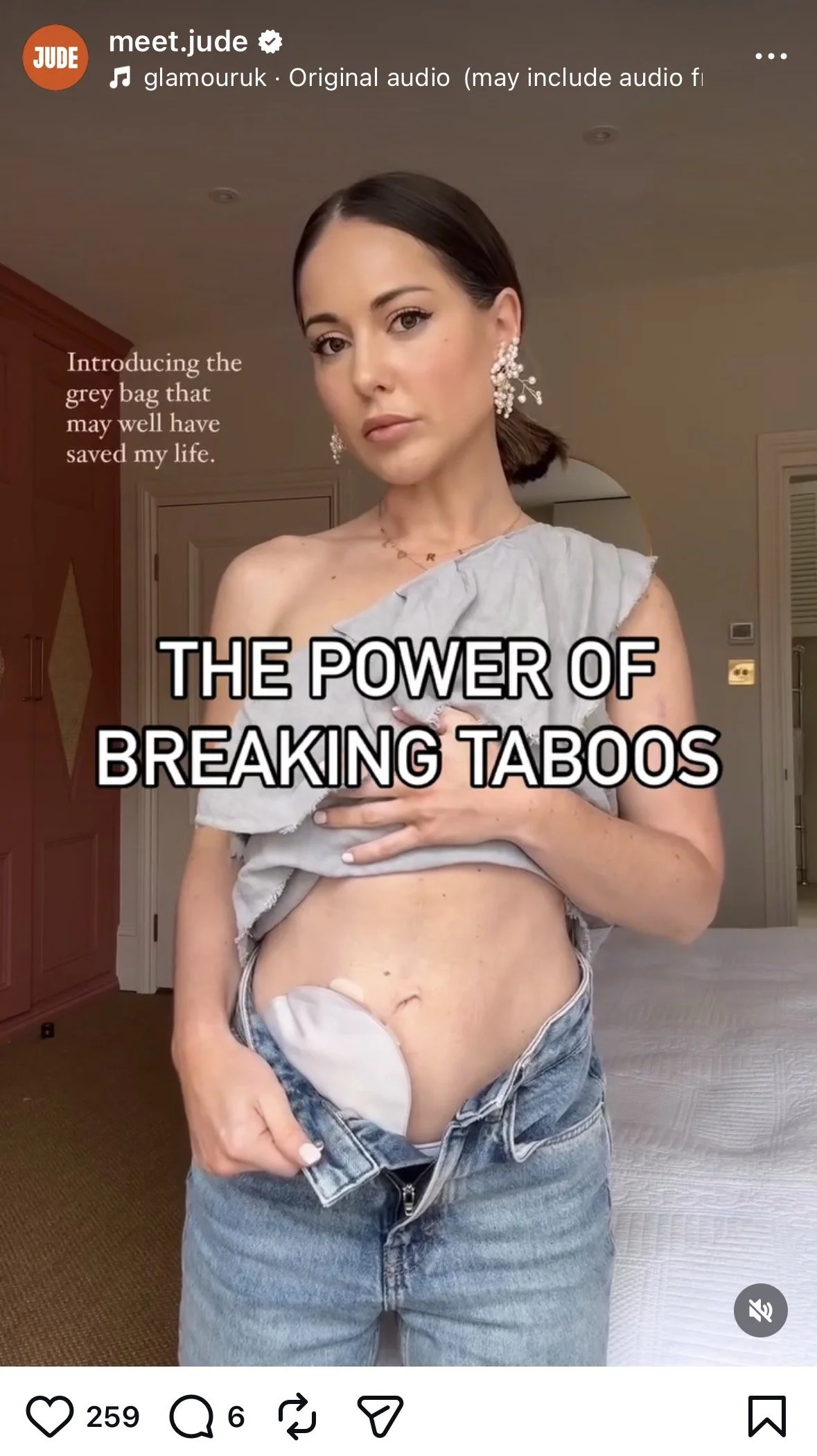 A woman is standing indoors, holding up her shirt to reveal a grey menstrual pad attached inside her jeans. She is looking directly at the camera. Text overlay says 'The power of breaking taboos'.