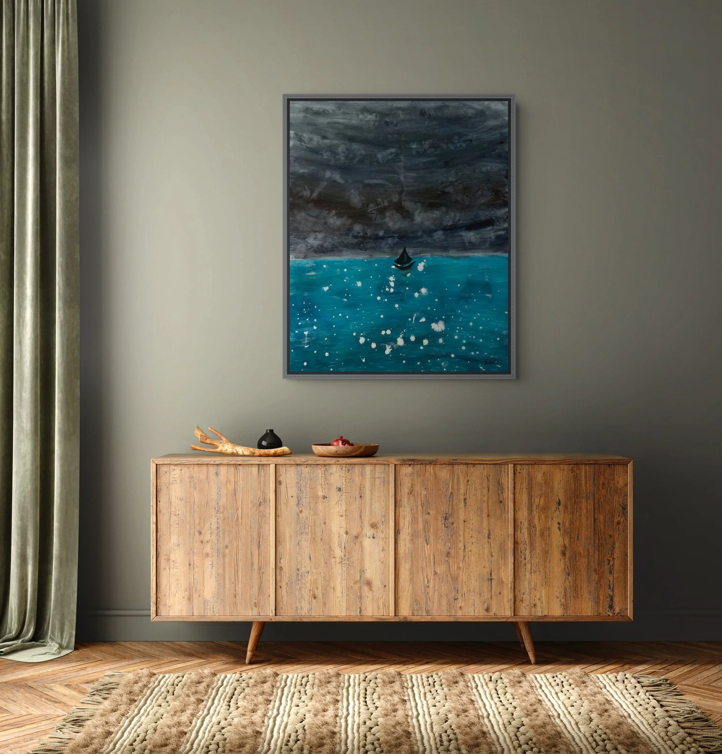 A mid-century modern wooden sideboard placed against a gray wall, topped with a black vase, a wooden bowl with pomegranate seeds, and a decorative wooden branch, with a large abstract painting of a stormy sea hanging above and a beige patterned rug on the wooden floor in the foreground.