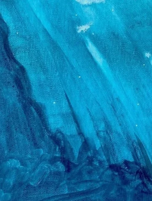 Close-up of blue painted canvas with visible brush strokes and texture.