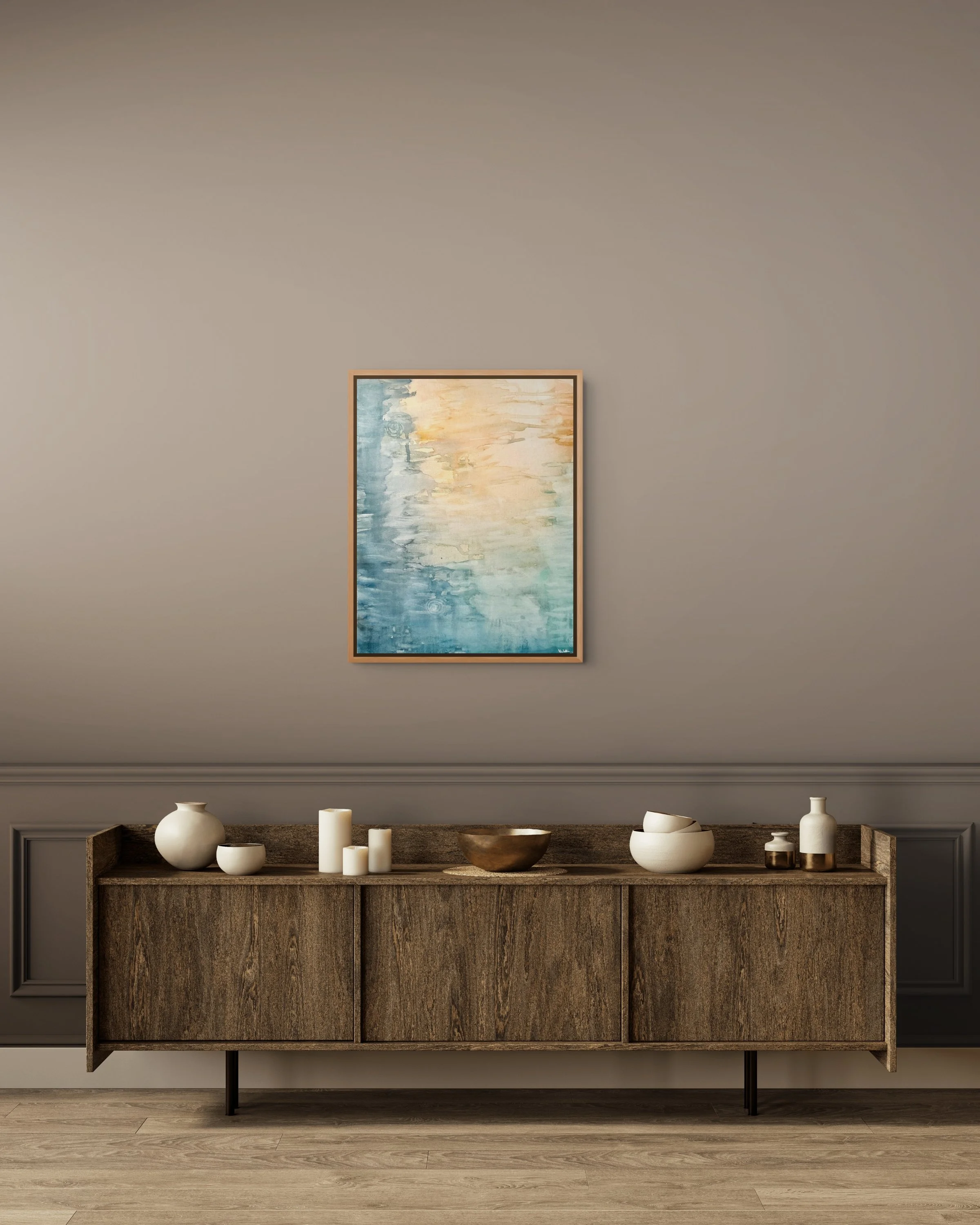 A wooden sideboard with decorative vases and candles on top, against a gray wall with a framed abstract watercolor painting hanging above.