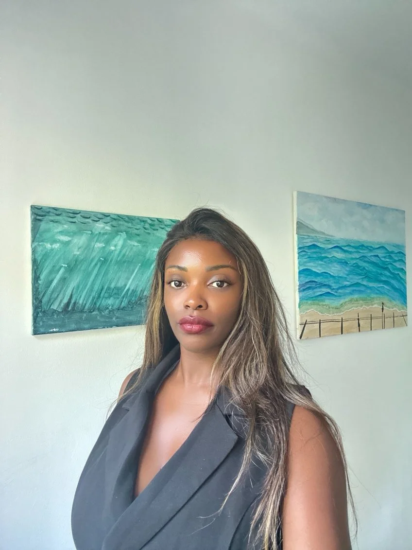 Violette presenting an ocean-inspired watercolor painting, wearing her signature blue tones and reflecting her connection to water and art.