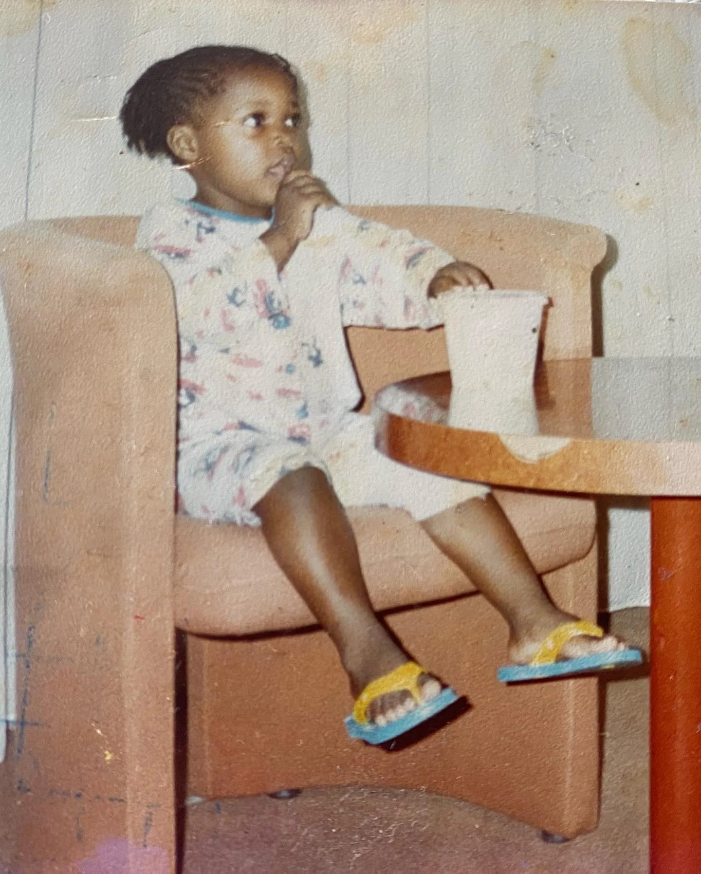 Childhood photograph of a Denise Balla sitting in a chair, used as the cover image for the poetry audiobook Living the Tingle of Remembering.