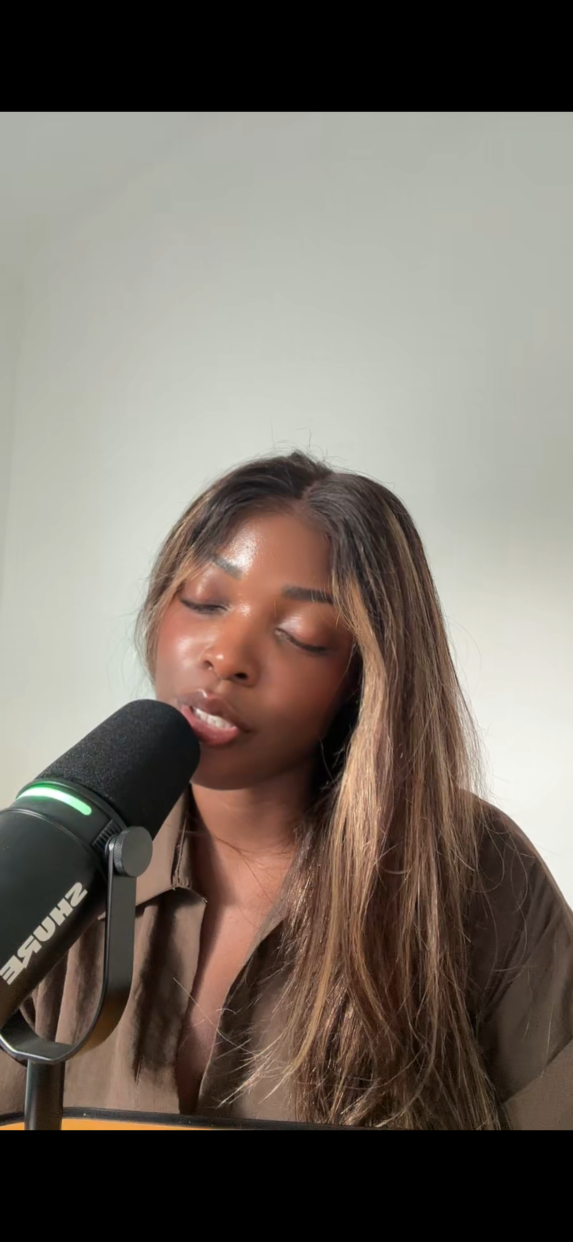 Denise Balla reading poetry into a microphone, bringing spoken poetry, voice and presence into her artistic practice.