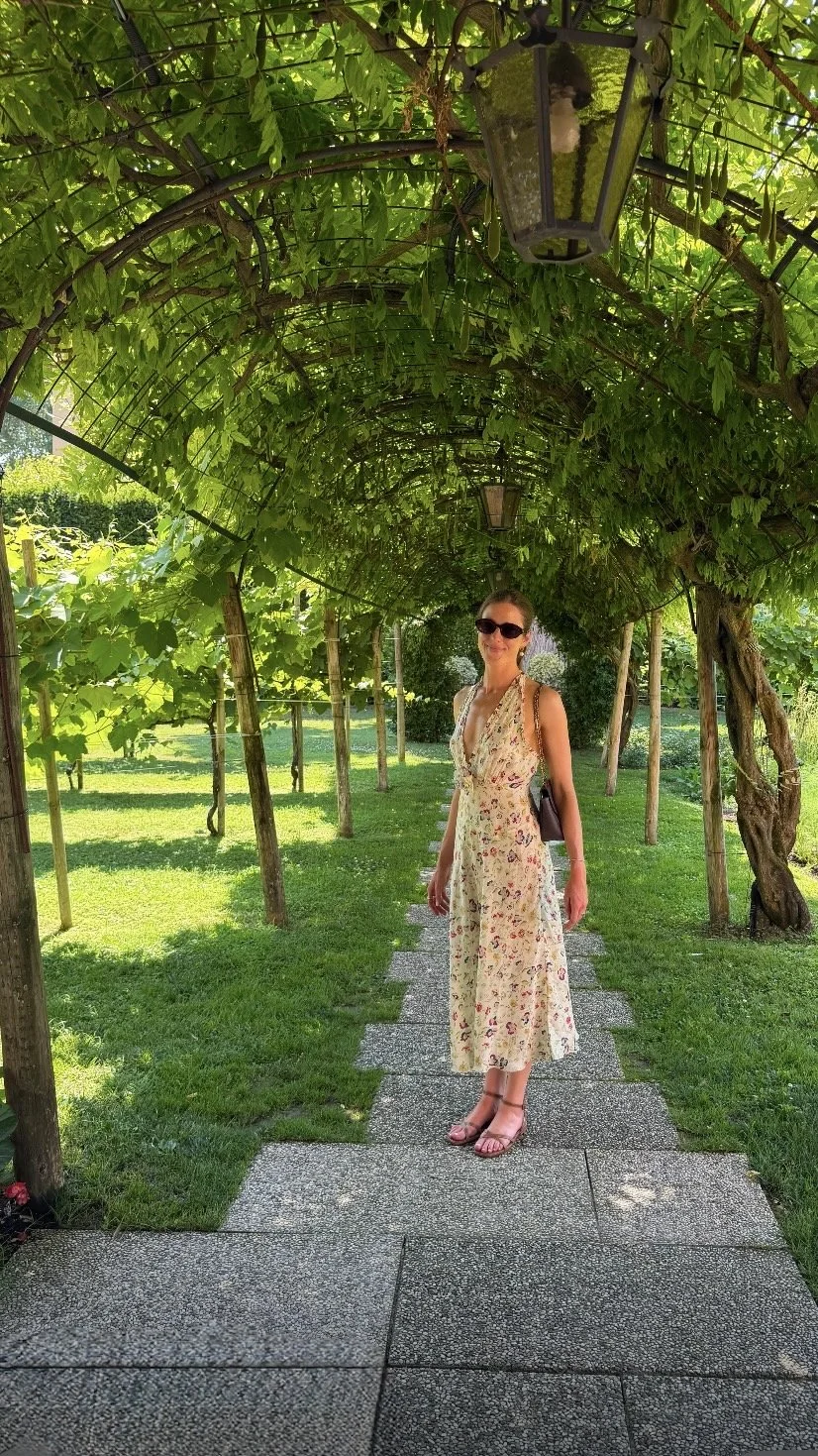 Tory beneath the vine pergola in the garden at Belmond Hotel Cipriani, Venice, on a Crossing honeymoon