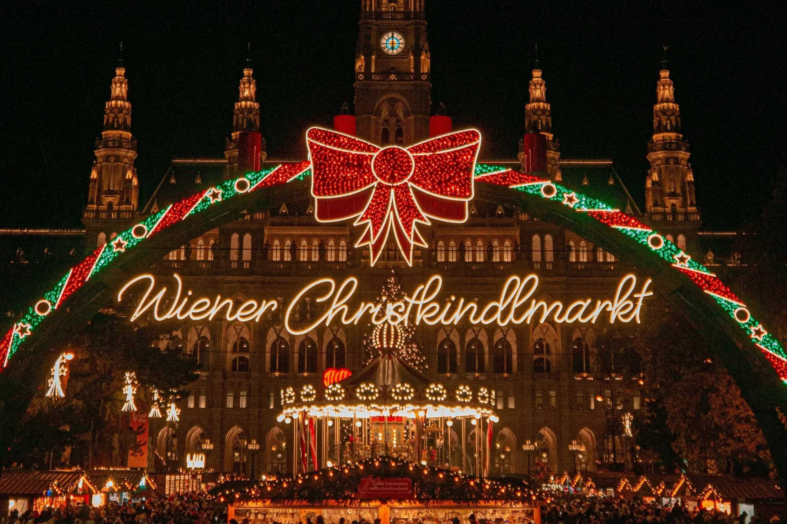 Christmas market on Rathausplatz, Vienna, framed by an illuminated arch in front of the City Hall.