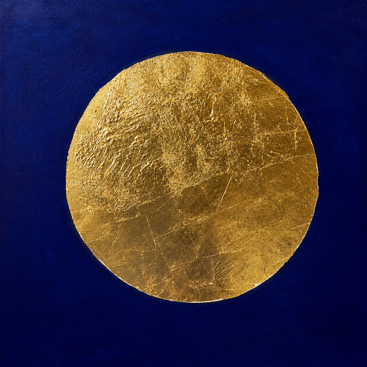 Close-up of a shiny, textured gold coin against a blue background.