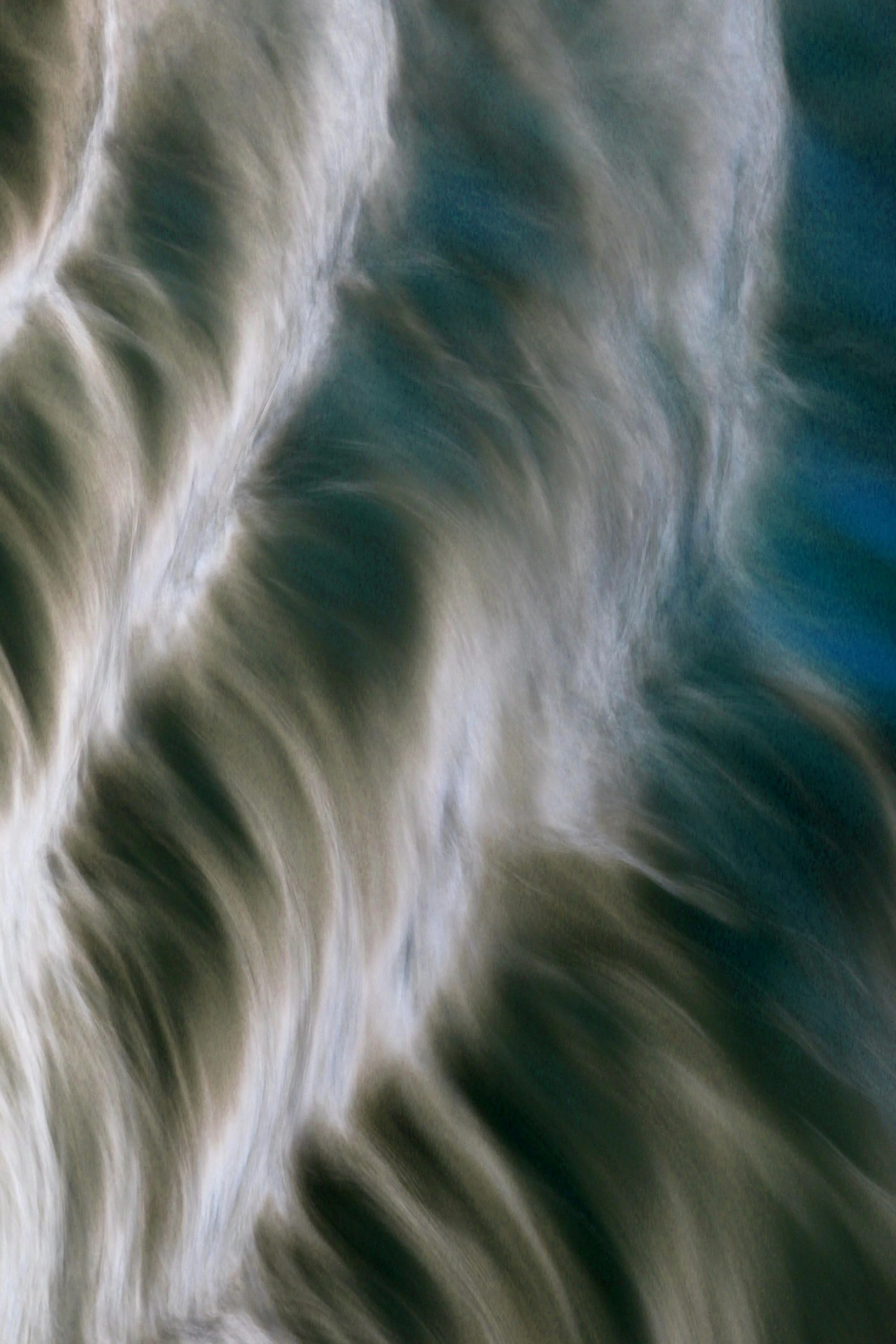 Blurred abstract image with swirling shades of beige, white, and dark blue.