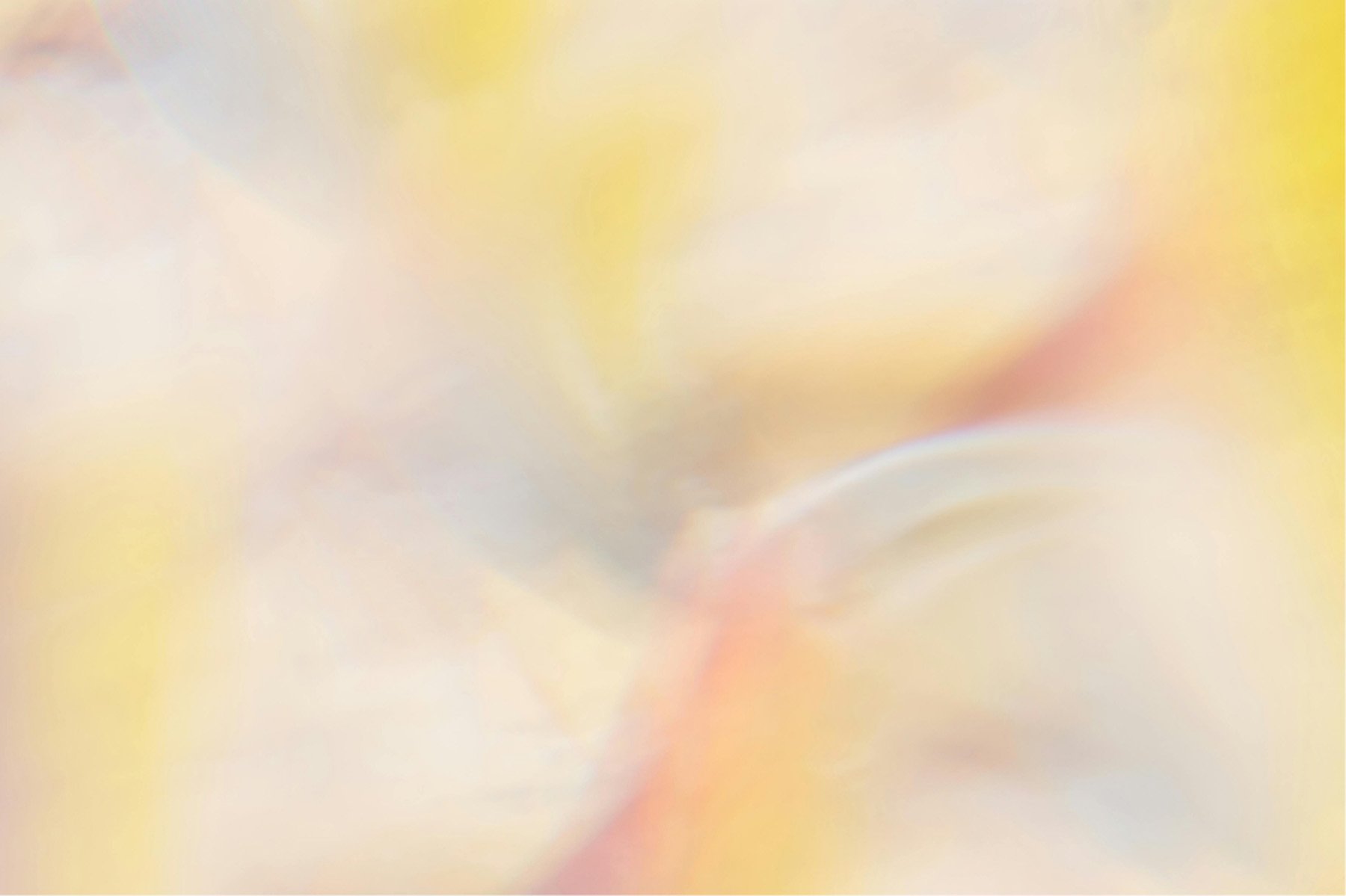 Abstract blurred pastel background with soft yellow, pink, white, and light orange hues.