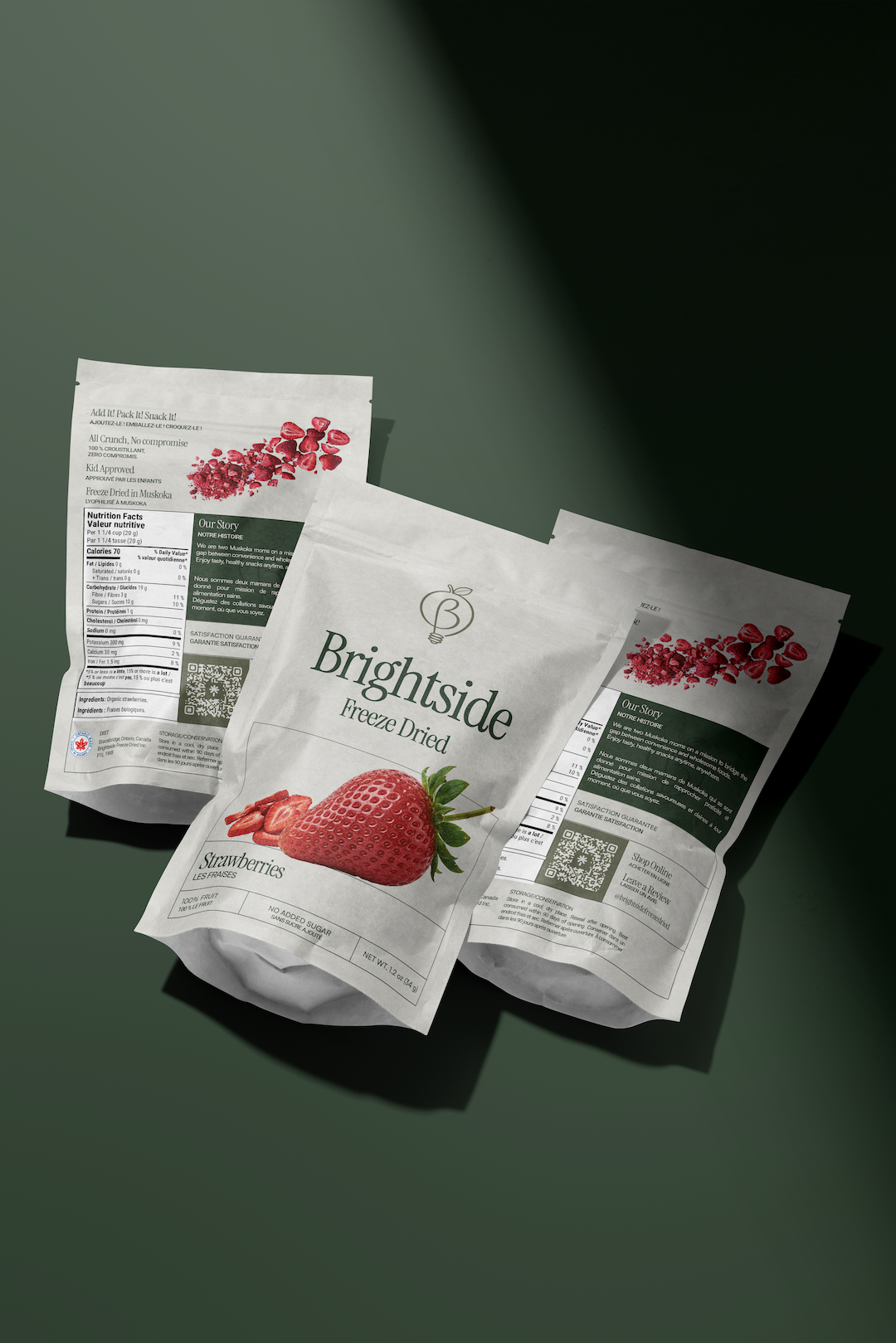 Three packages of Brightside freeze dried strawberries on a green surface.