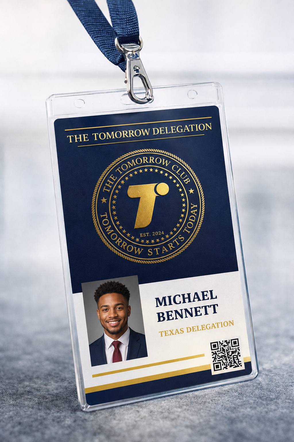 A clear plastic conference badge with a dark blue and gold design, displaying a photo of a smiling young man in a suit and tie, named Michael Bennett, representing Texas, with a QR code.