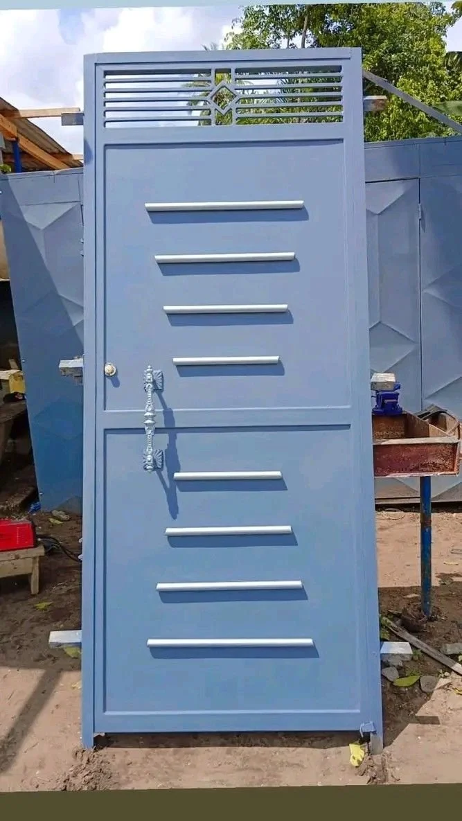Une porte bleue design avec des barres horizontales et une partie ajourée en haut, installée en extérieur, entourée de murs en construction.