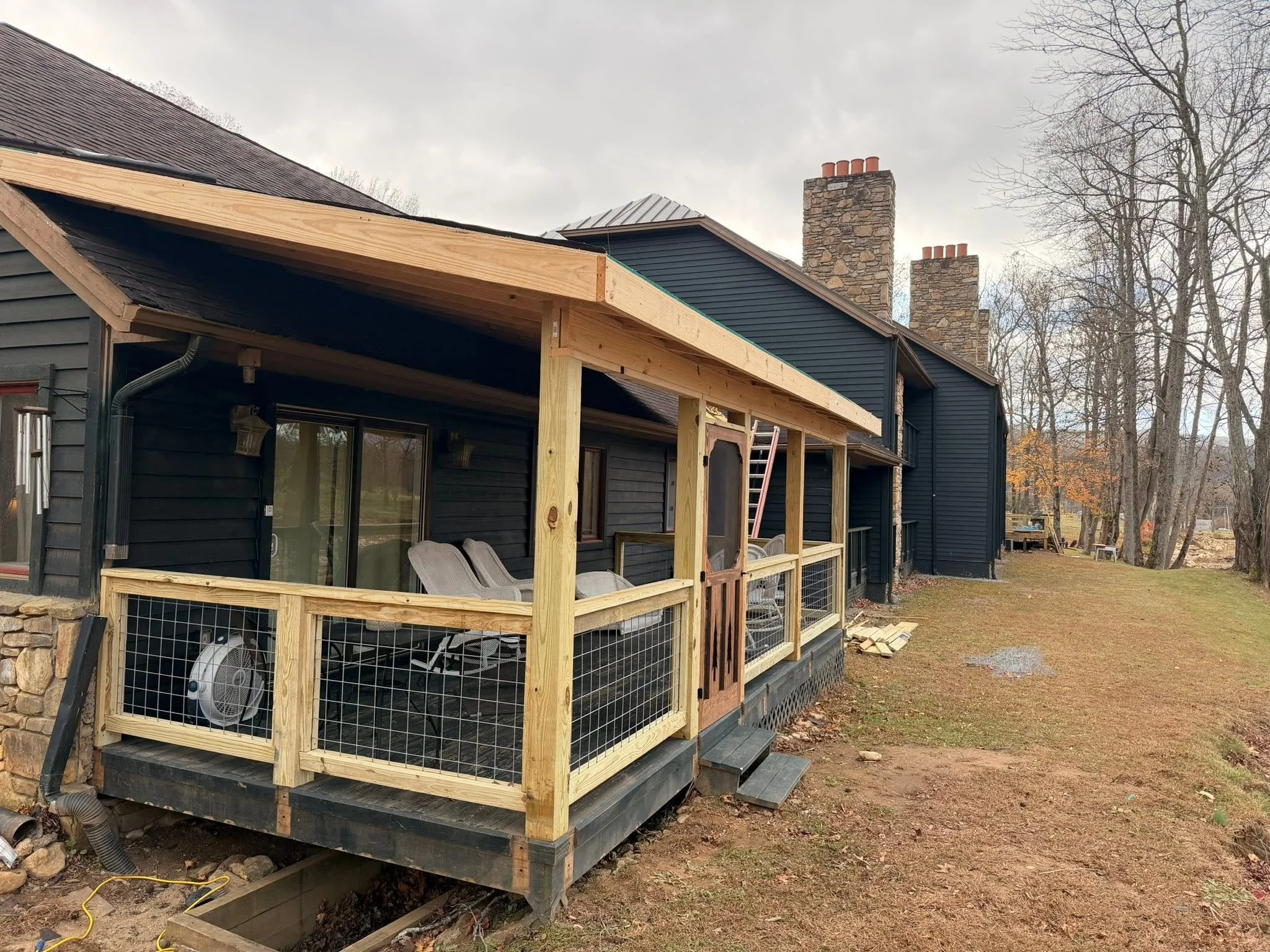Custom covered porch under construction with pressure-treated framing by Modern Edge Builders.