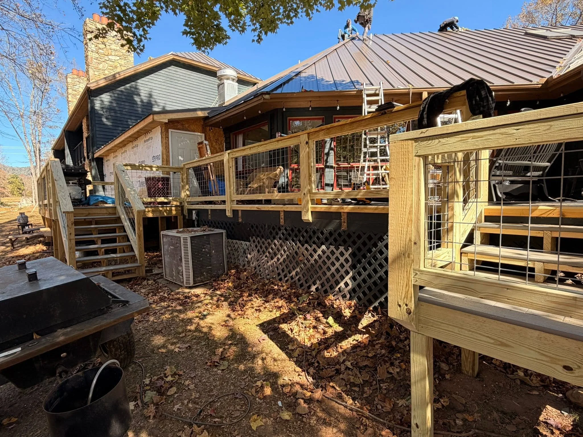 Custom pressure-treated deck with wood stairs and cable railing installed by Modern Edge Builders.