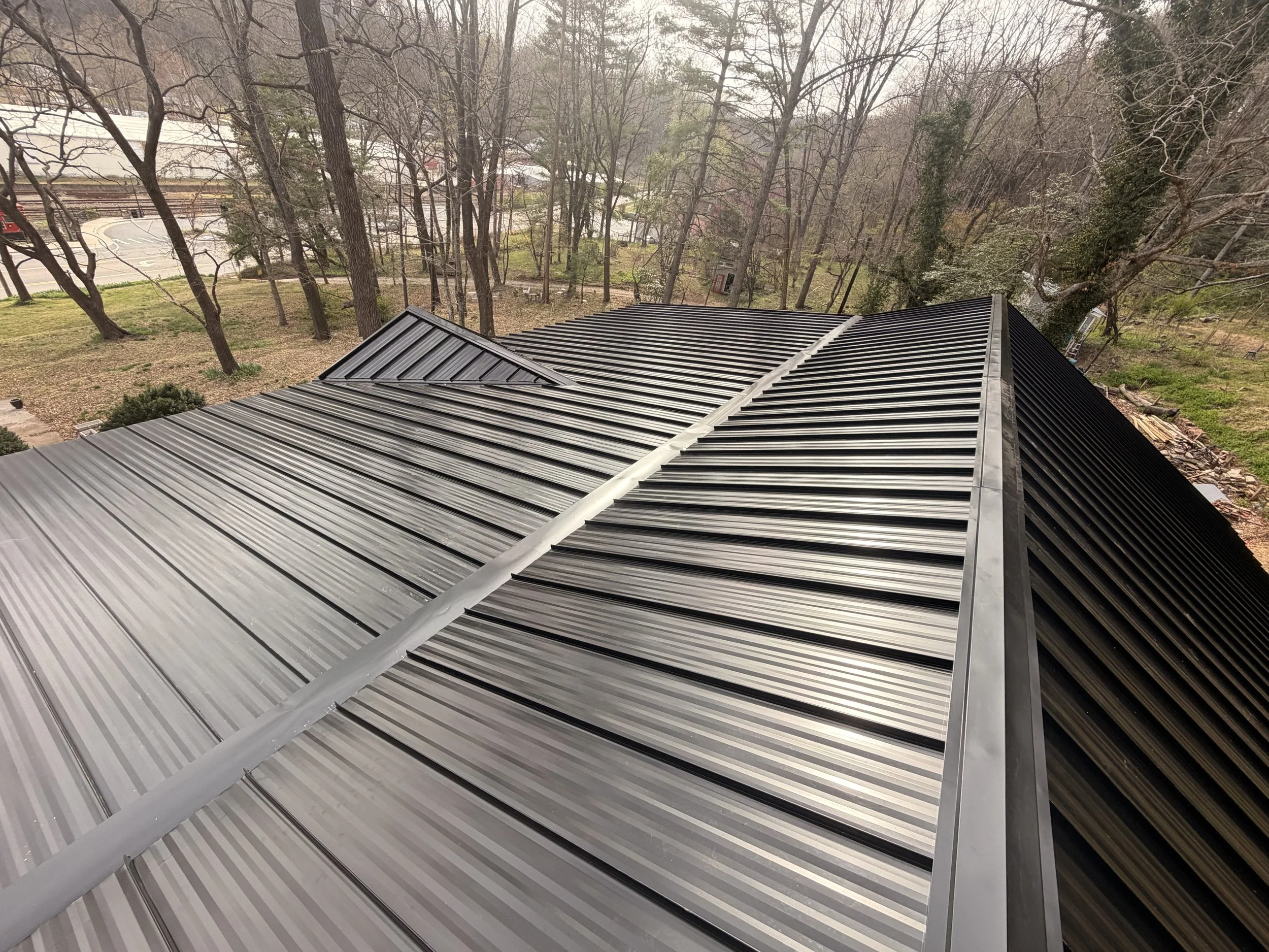 Black standing seam metal roof installed on a custom residential home by Modern Edge Builders in Western North Carolina.