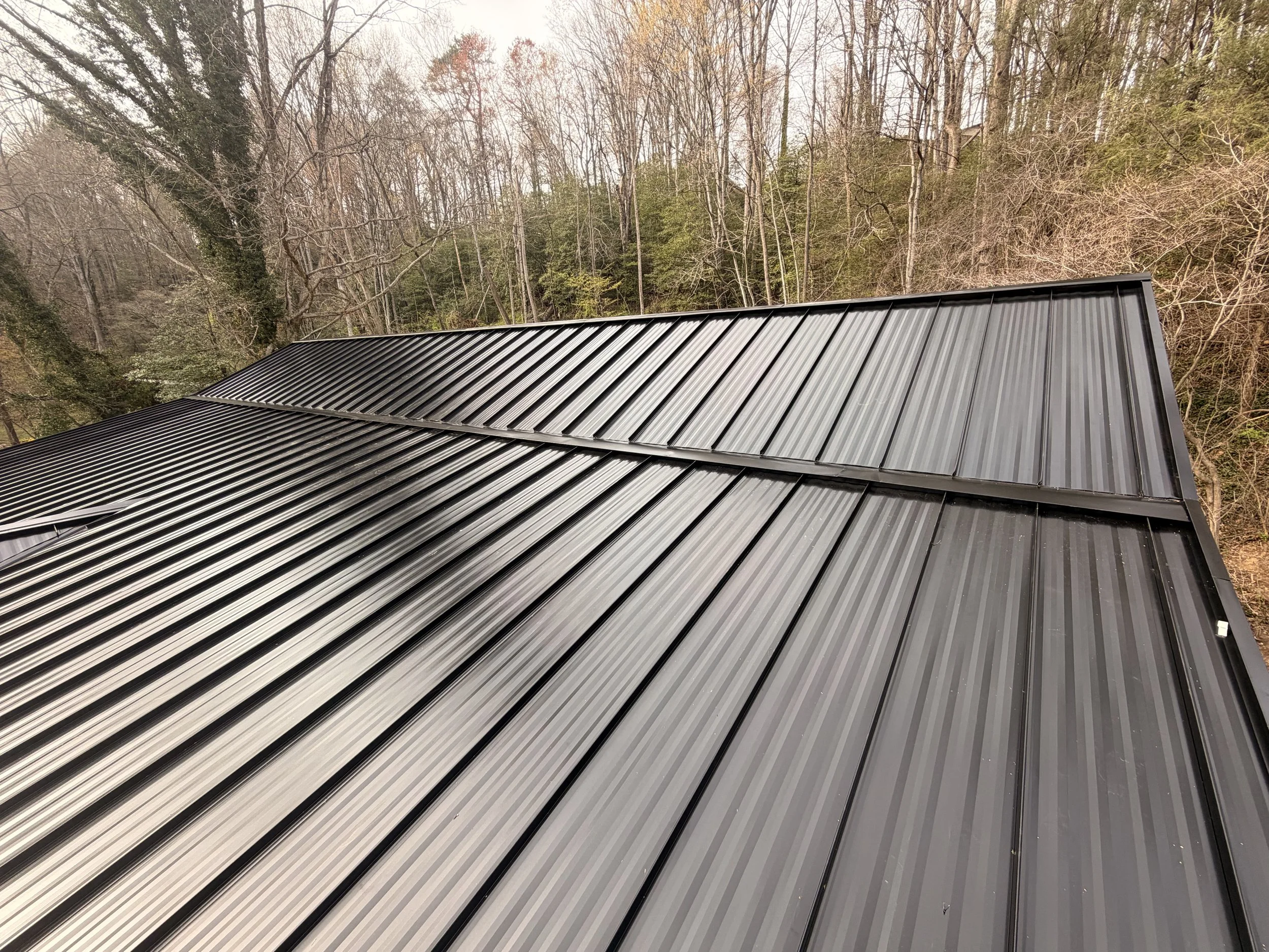 Residential metal roofing installation on a custom home featuring premium steel roofing panels in Western North Carolina.