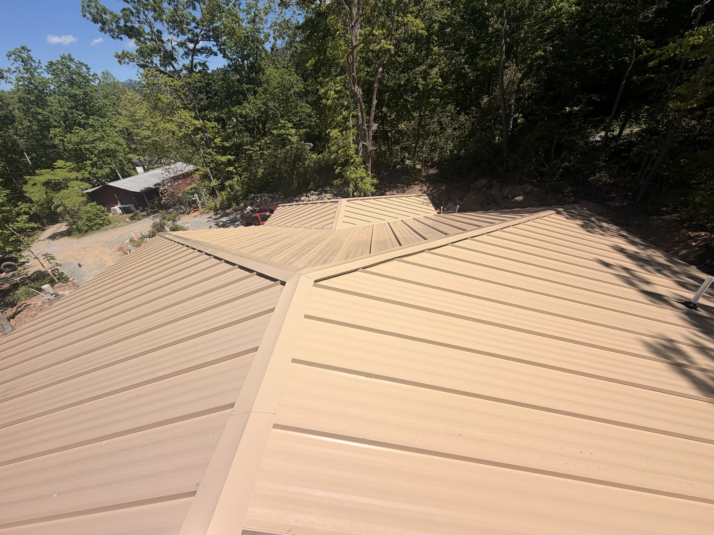 Custom brown standing seam metal roof installed by Modern Edge Builders on a residential home in Western North Carolina.