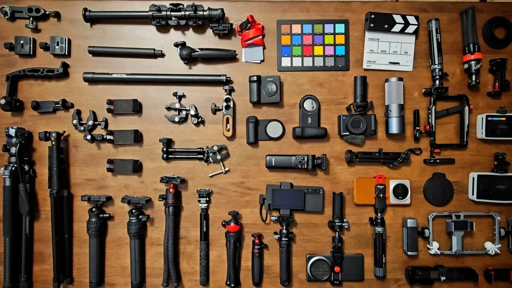 Jason Elpheus Wong's camera and video equipment, including tripods, stabilizers, cameras, lenses, and accessories arranged on a wooden surface.