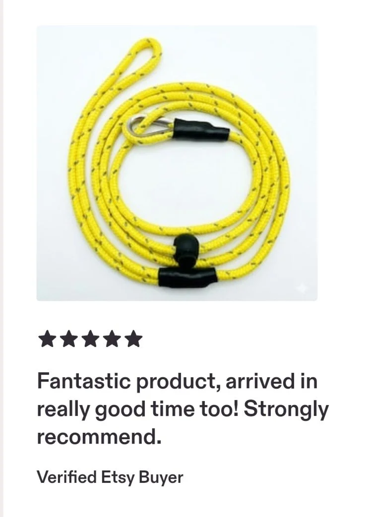 Yellow braided rope with metal clip and black rubber ends, coiled in a circle on a white background.