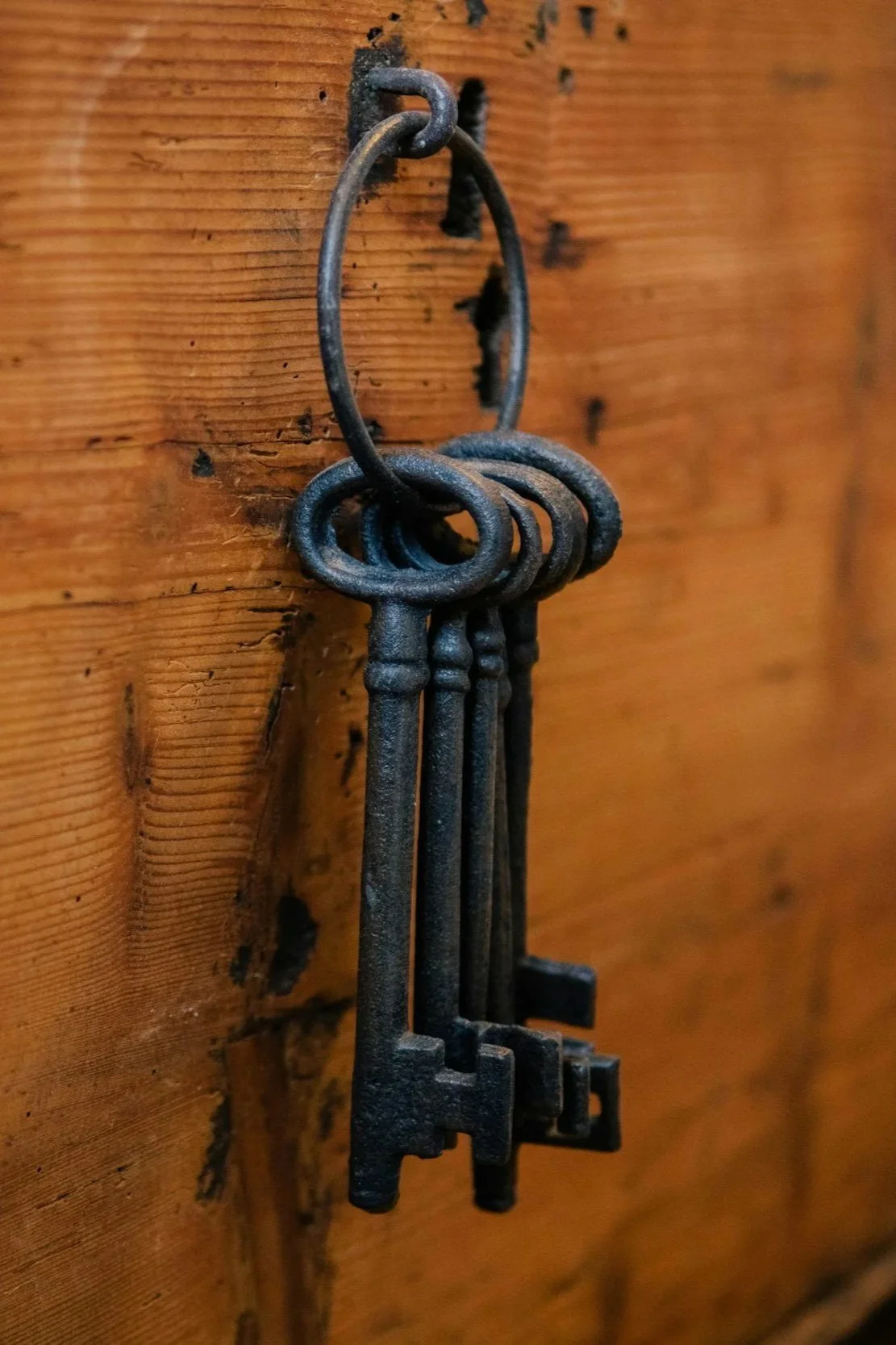 a ring of antique keys hanging on a hook