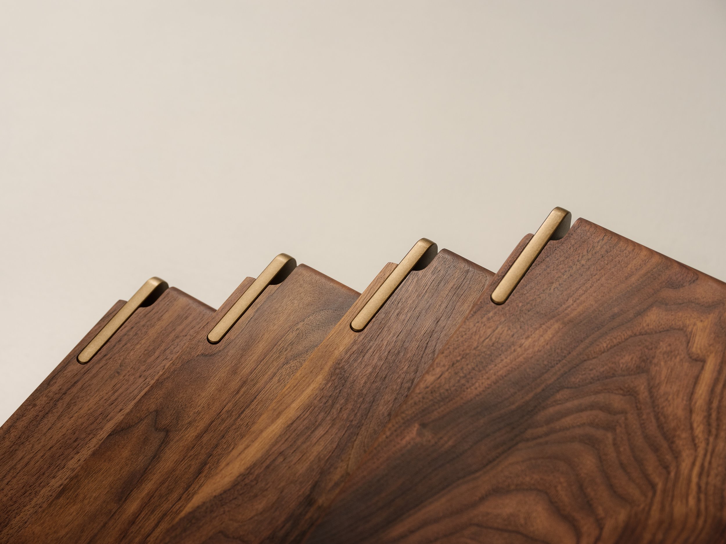 Close-up of wooden slats or panels with rounded edges and gold-colored holders, arranged in a curved pattern.
