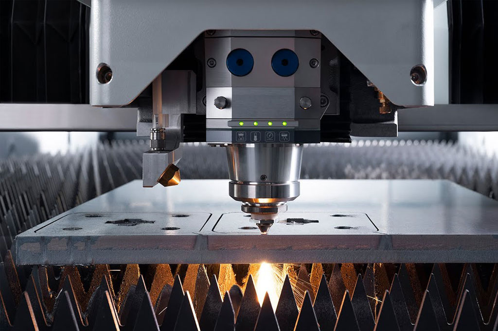 A laser cutting machine cutting through metal with sparks flying.