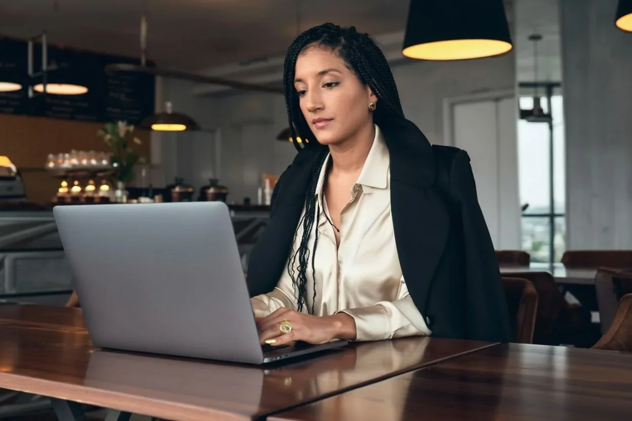 content strategist at I Got Creative, working on a laptop in a modern cafe