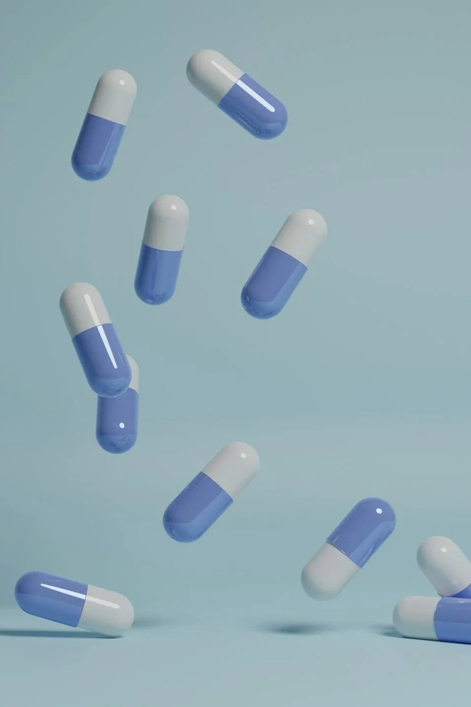Blue and white capsules floating against a light blue background.