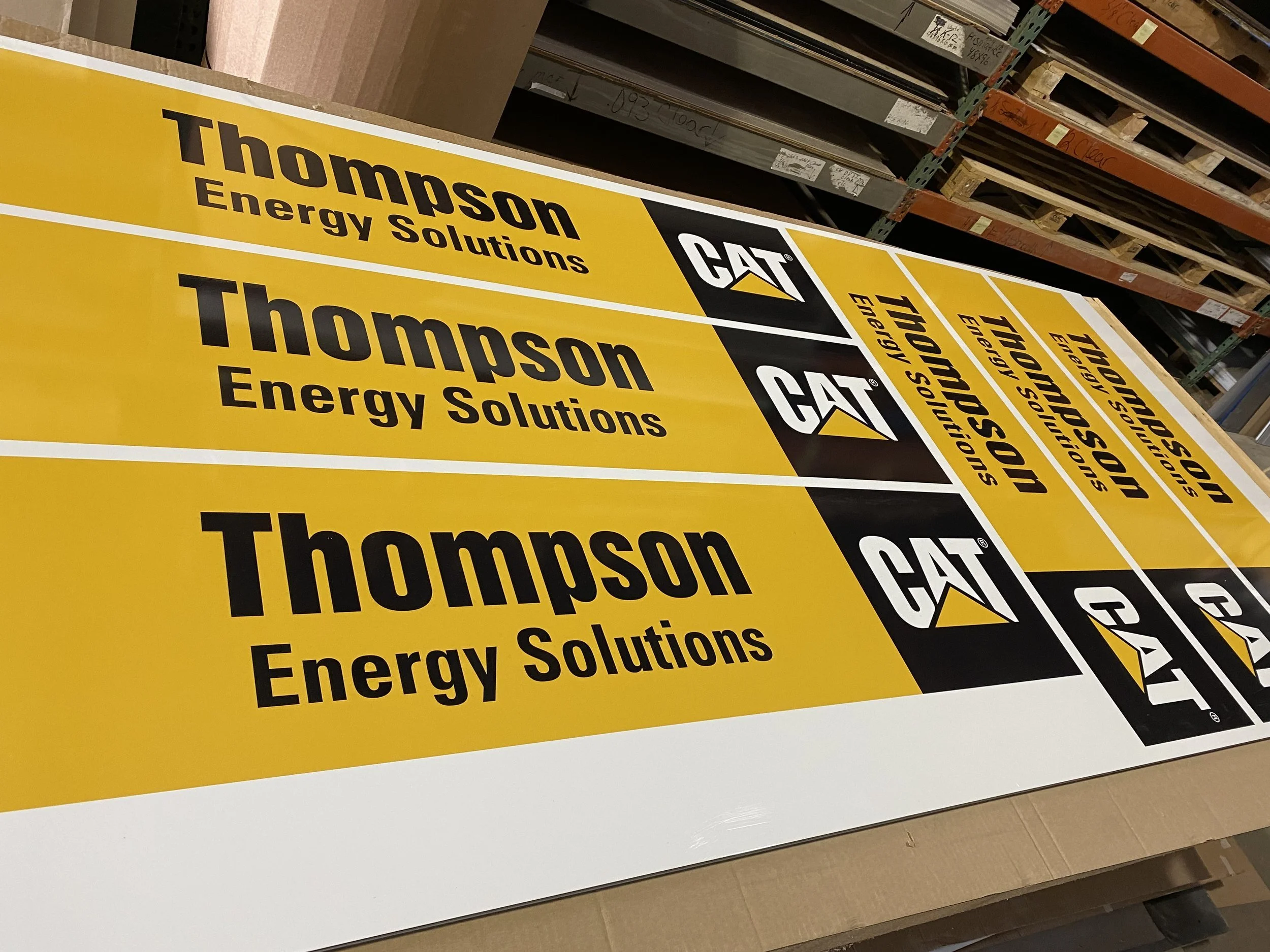 Large yellow sign with black text reading 'Thompson Energy Solutions' and a black and yellow Caterpillar (CAT) logo.