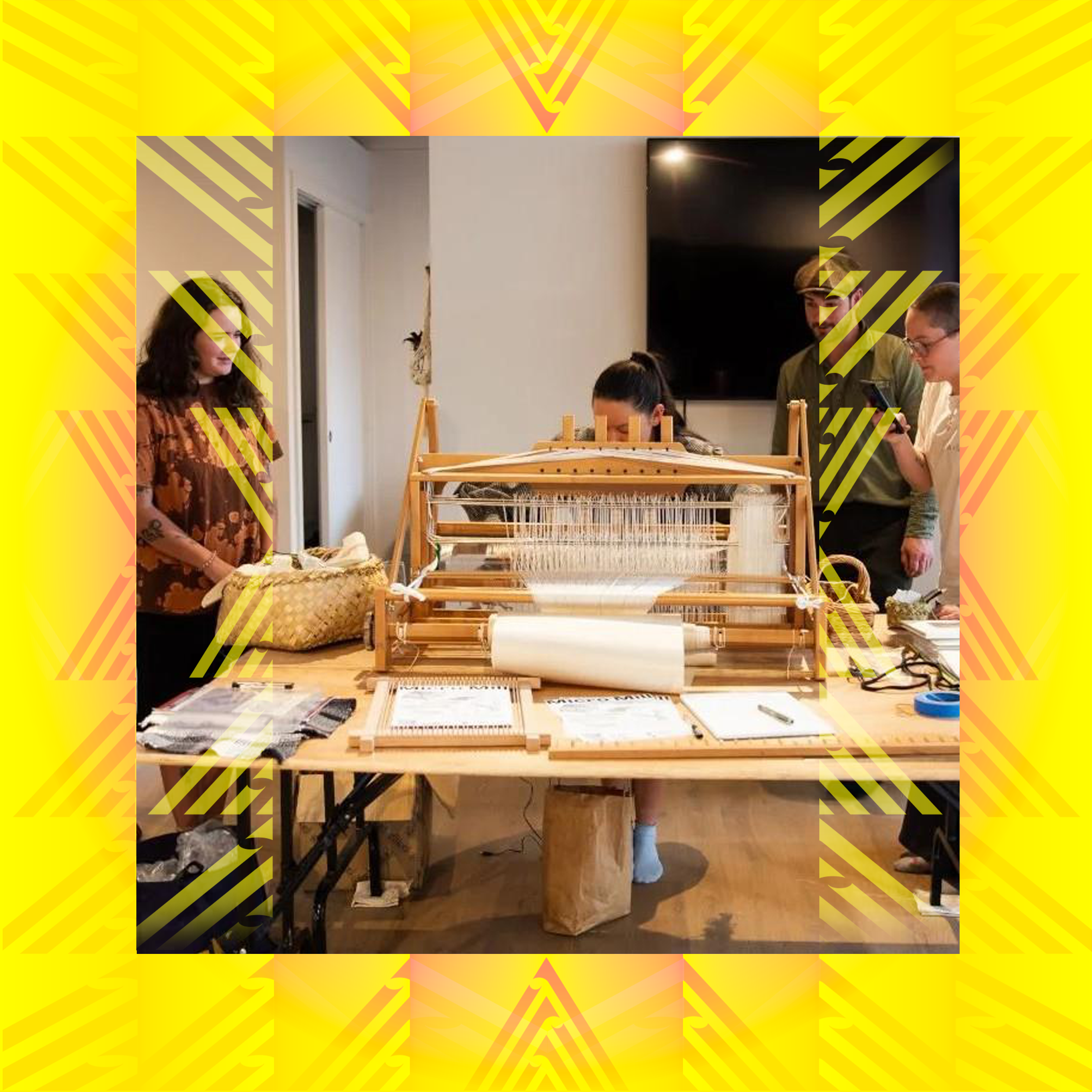 People participating in an Urban Dream Brokerage workshop event. People are gathered around a table, working on a weaving loom in a well-lit room.