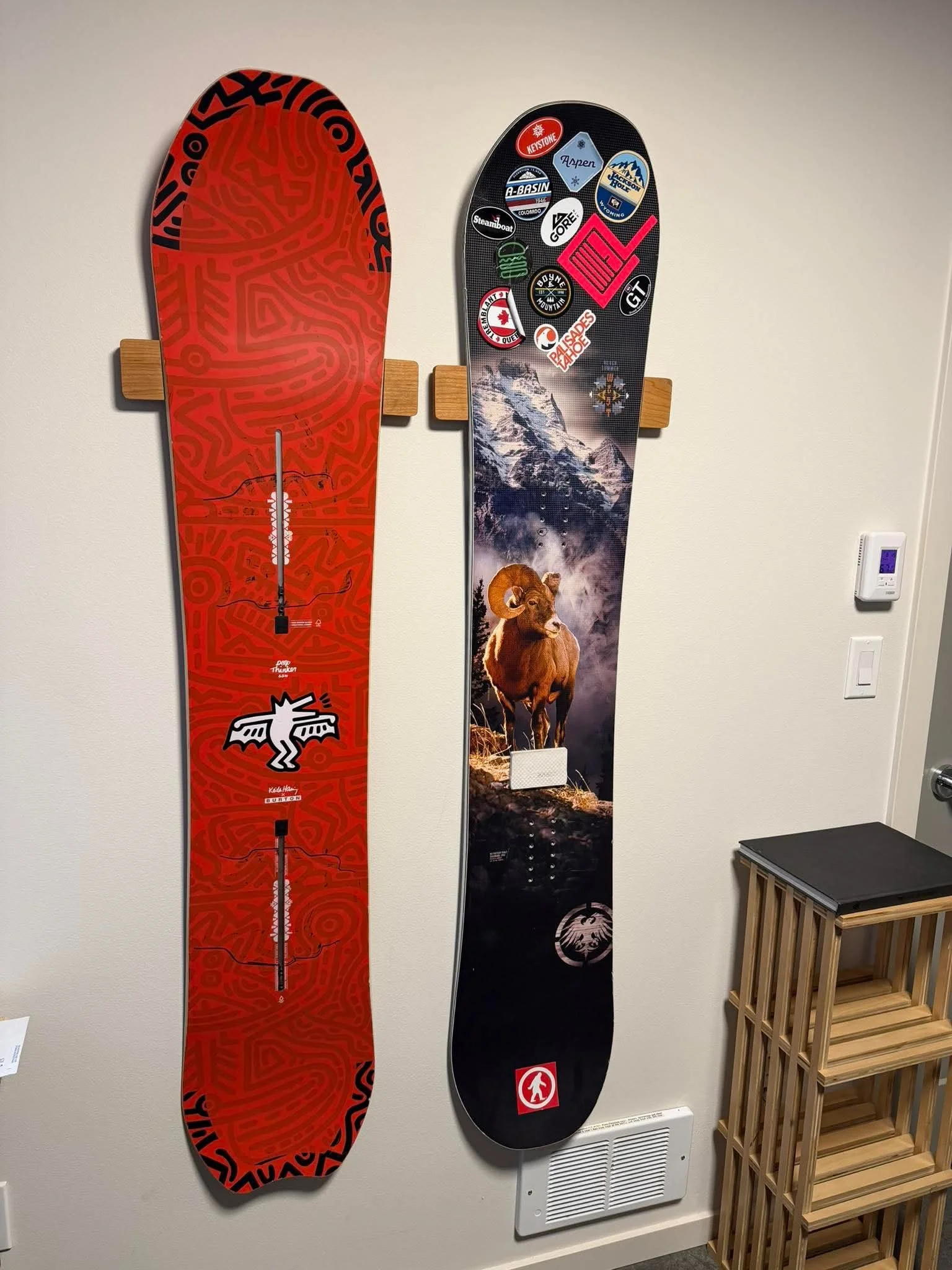 Two snowboards mounted vertically on Method Mounts™ on a white wall. The Method Mounts™ are at the same height and next to each other while the two snowboards are also at the same relative height thanks to the adjustability in the mounts.