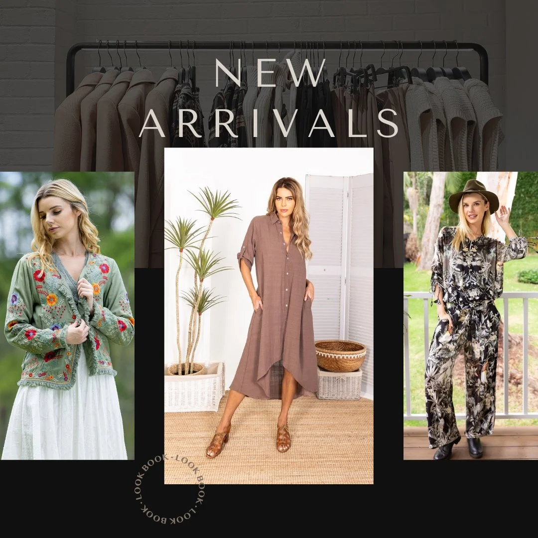 A promotional display for new arrivals in clothing. The background features a clothing rack with beige and white garments. Three women are modeling different outfits: one in a green embroidered jacket and white skirt, one in a brown oversized shirt dress, and one in a black and white floral jumpsuit with a wide-brimmed hat.