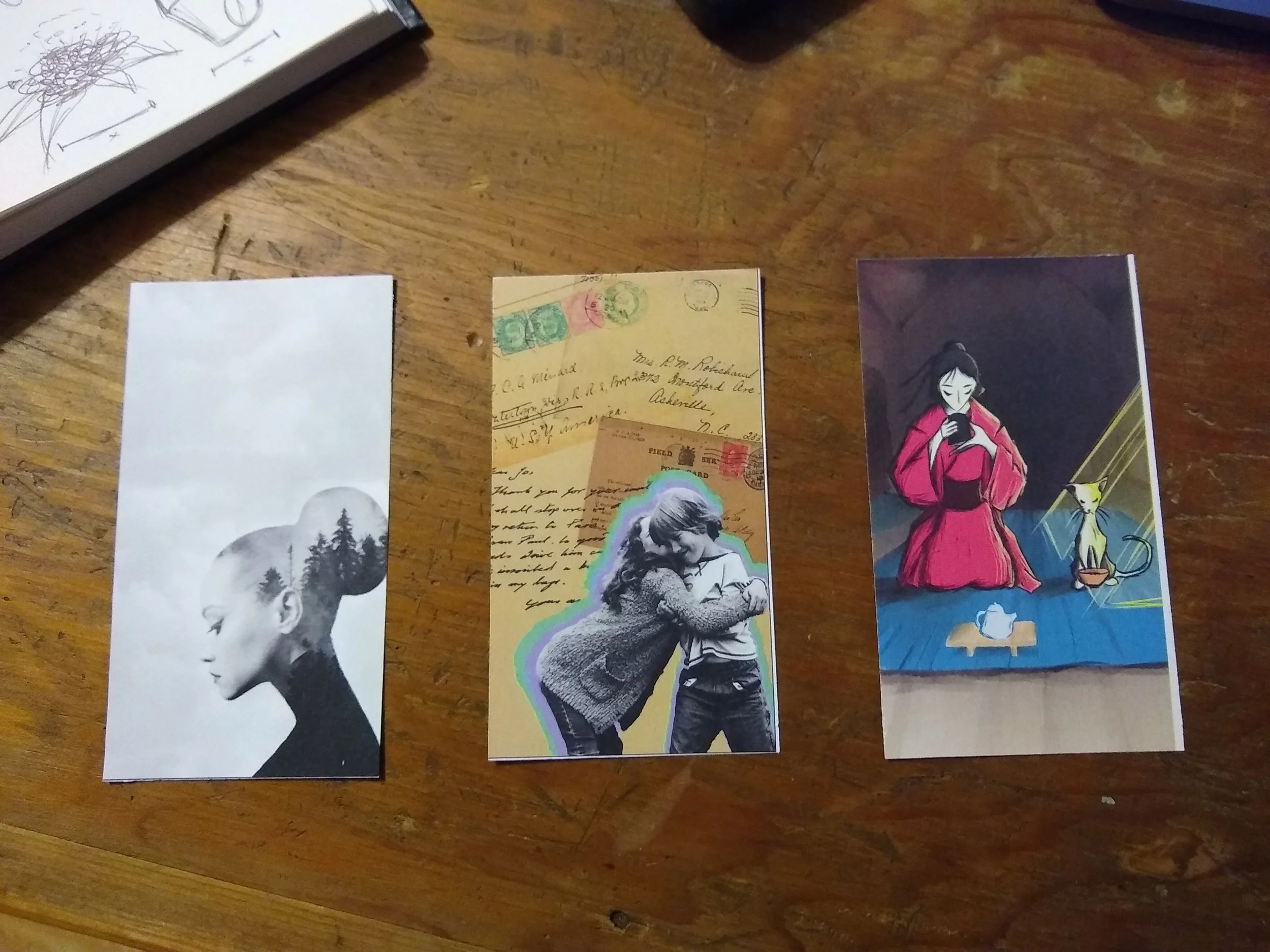 Various bookmarks and artwork on a wooden table.