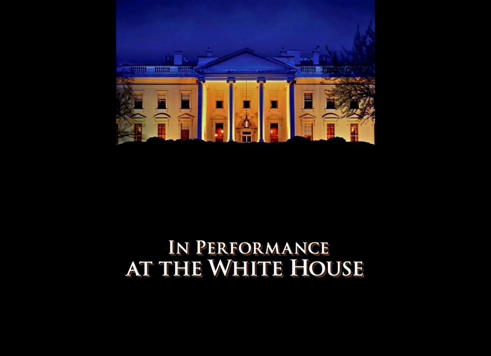 The White House illuminated at night with a dark sky and trees in the foreground.