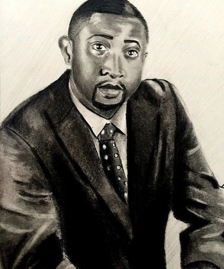 A black and white drawing of a man in a suit and tie, with short hair and a surprised or curious facial expression, sitting with one arm resting on a surface.