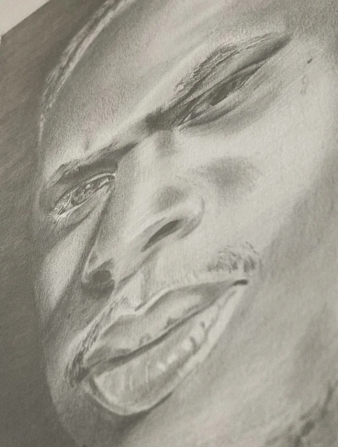 A detailed black and white graphite pencil drawing of a person's face, focusing on the eyes, nose, and lips.
