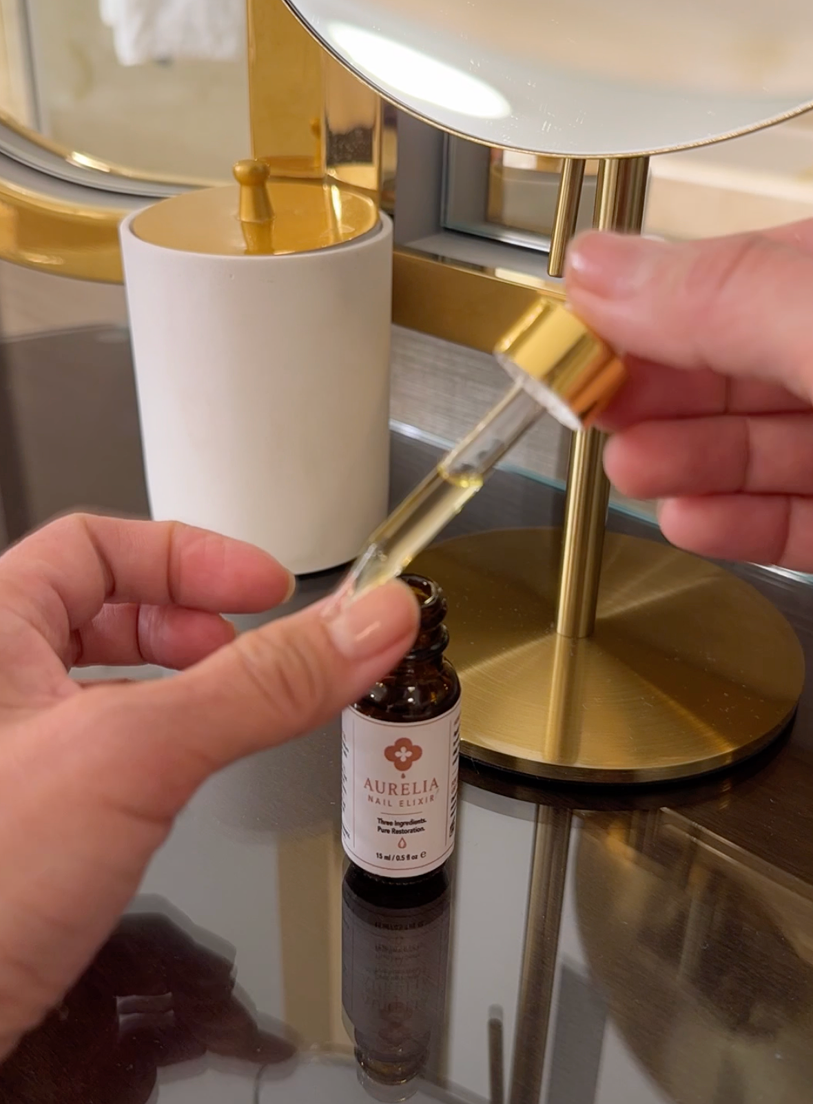 Applying Aurelia Nail Elixir to nourish nails and cuticles with jojoba oil and vitamin E.