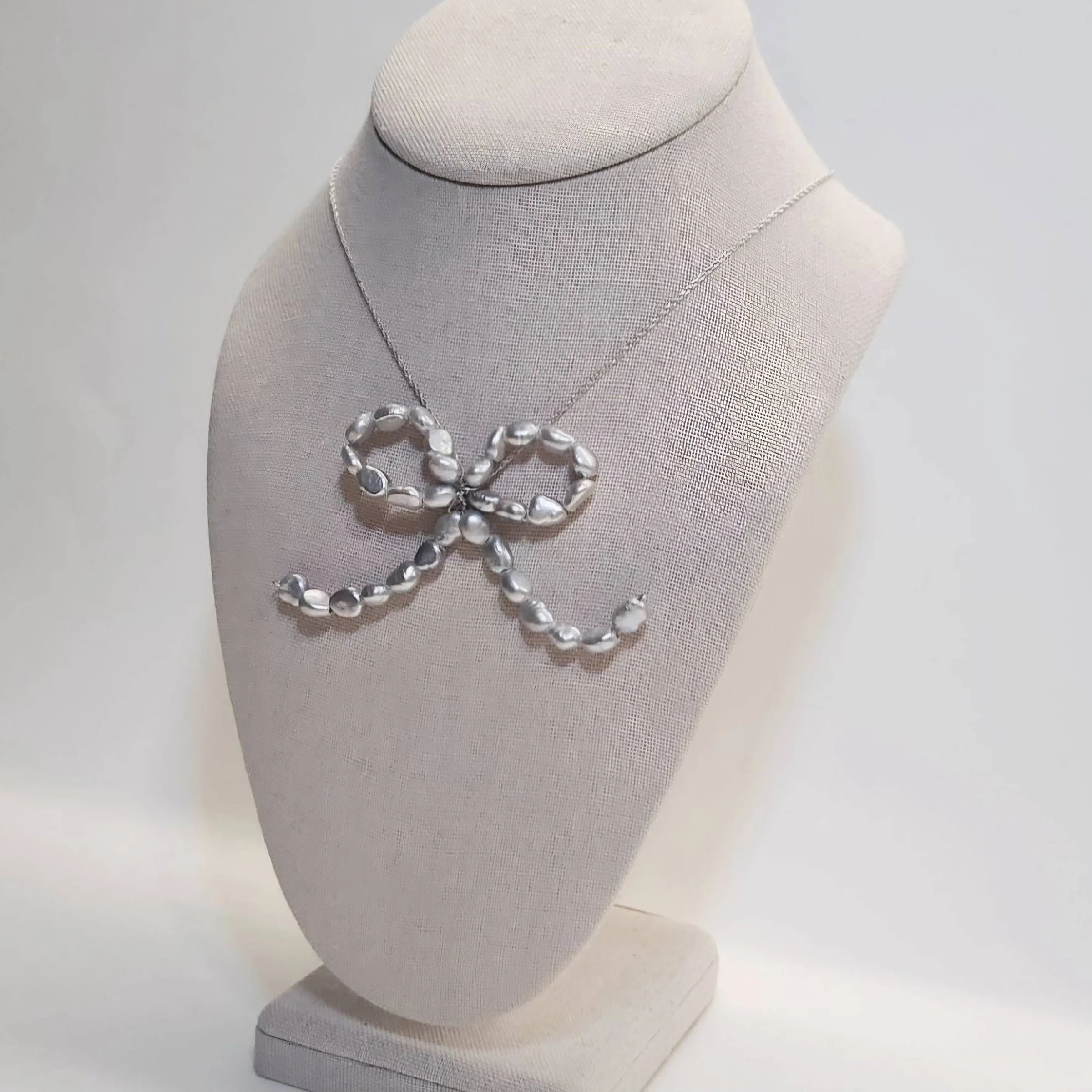 Bow charm necklace featuring genuine silver freshwater pearls on a sterling silver chain (2024)