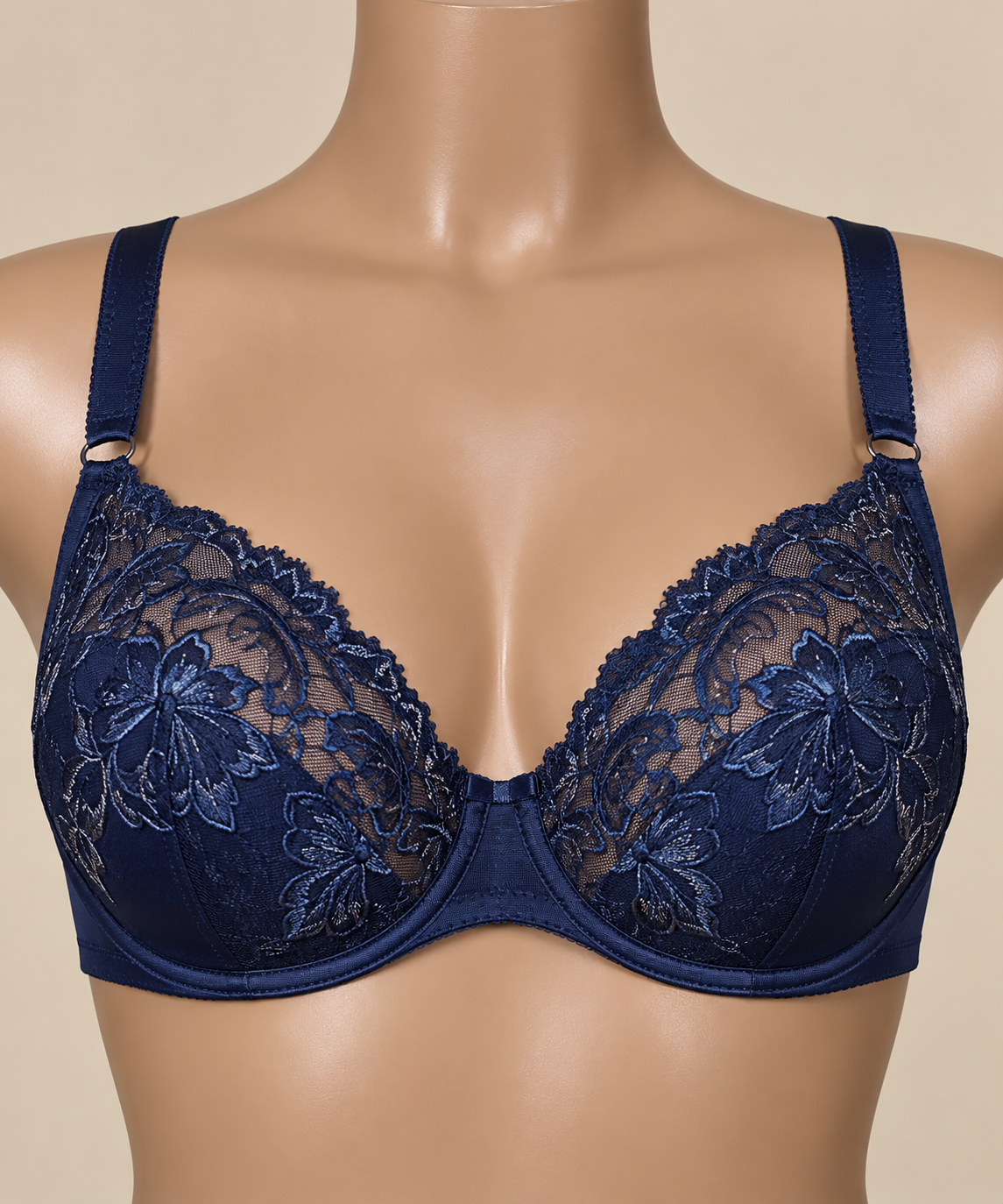 Close-up of a mannequin wearing a navy blue lace bra with floral embroidery.