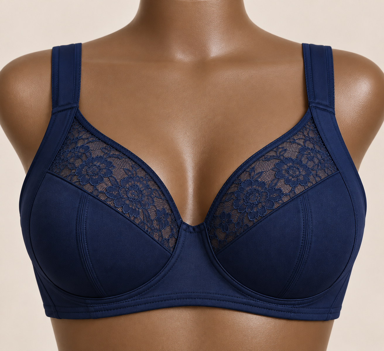 Close-up of a mannequin wearing a navy blue bra with lace floral panels on the cups.