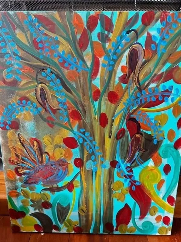 Colorful painting of a tree with blue, red, orange, and green leaves, a bird at the bottom left, and a blue background.