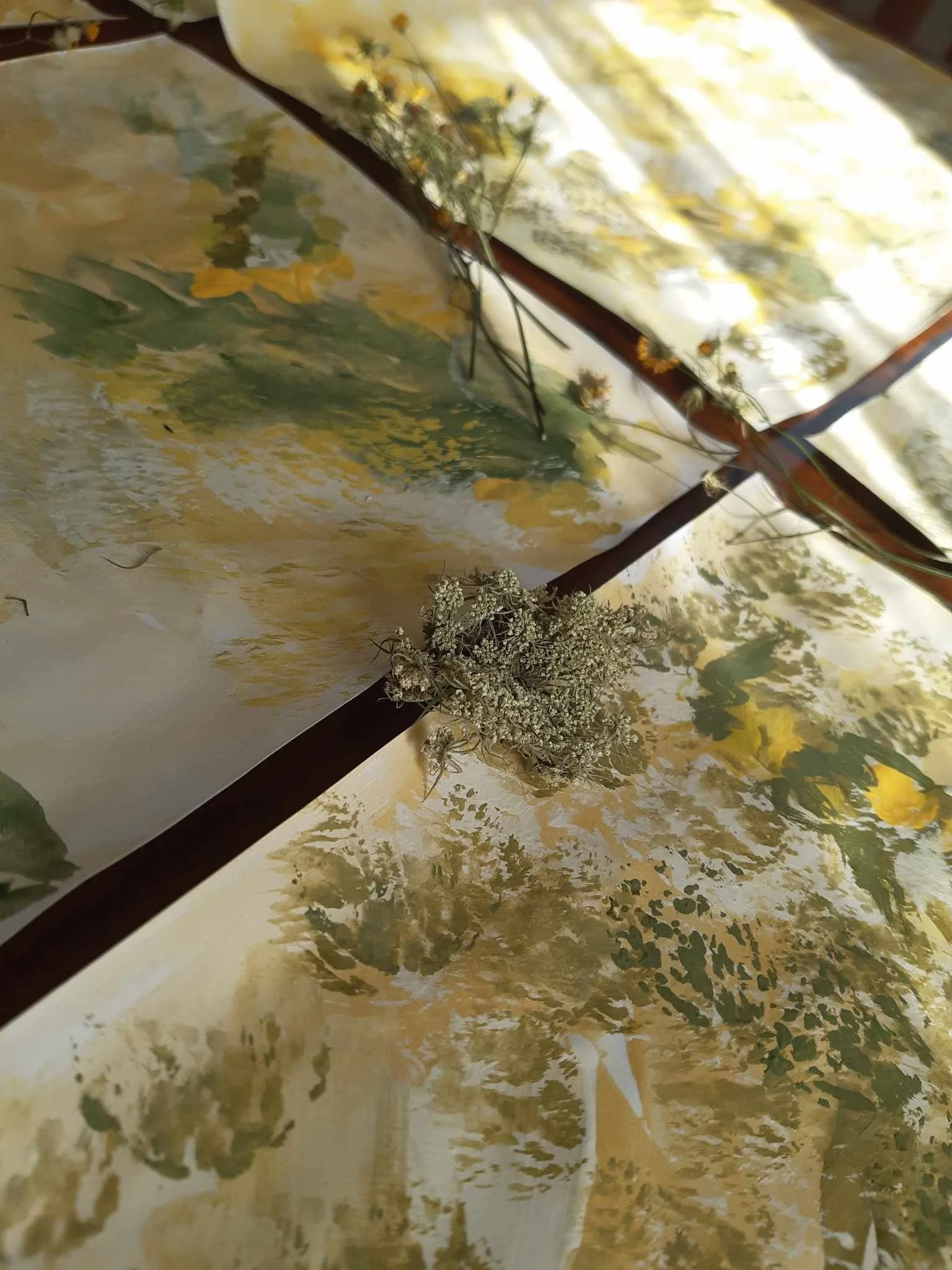 Close-up view of a floral patterned paper or fabric with some dried flowers placed on top.