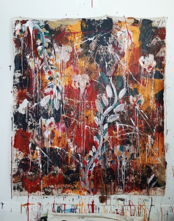 Abstract expressionist painting with splashes of red, black, yellow, and white, featuring floral and leaf motifs.