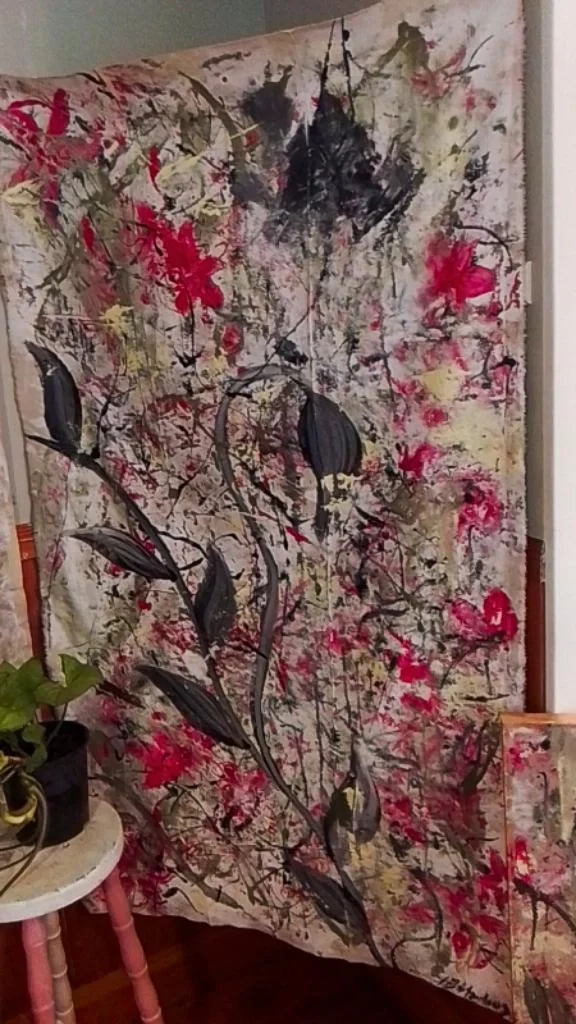 Abstract floral painting with pink, yellow, black, and green colors, featuring large dark leaves and delicate branching effects.