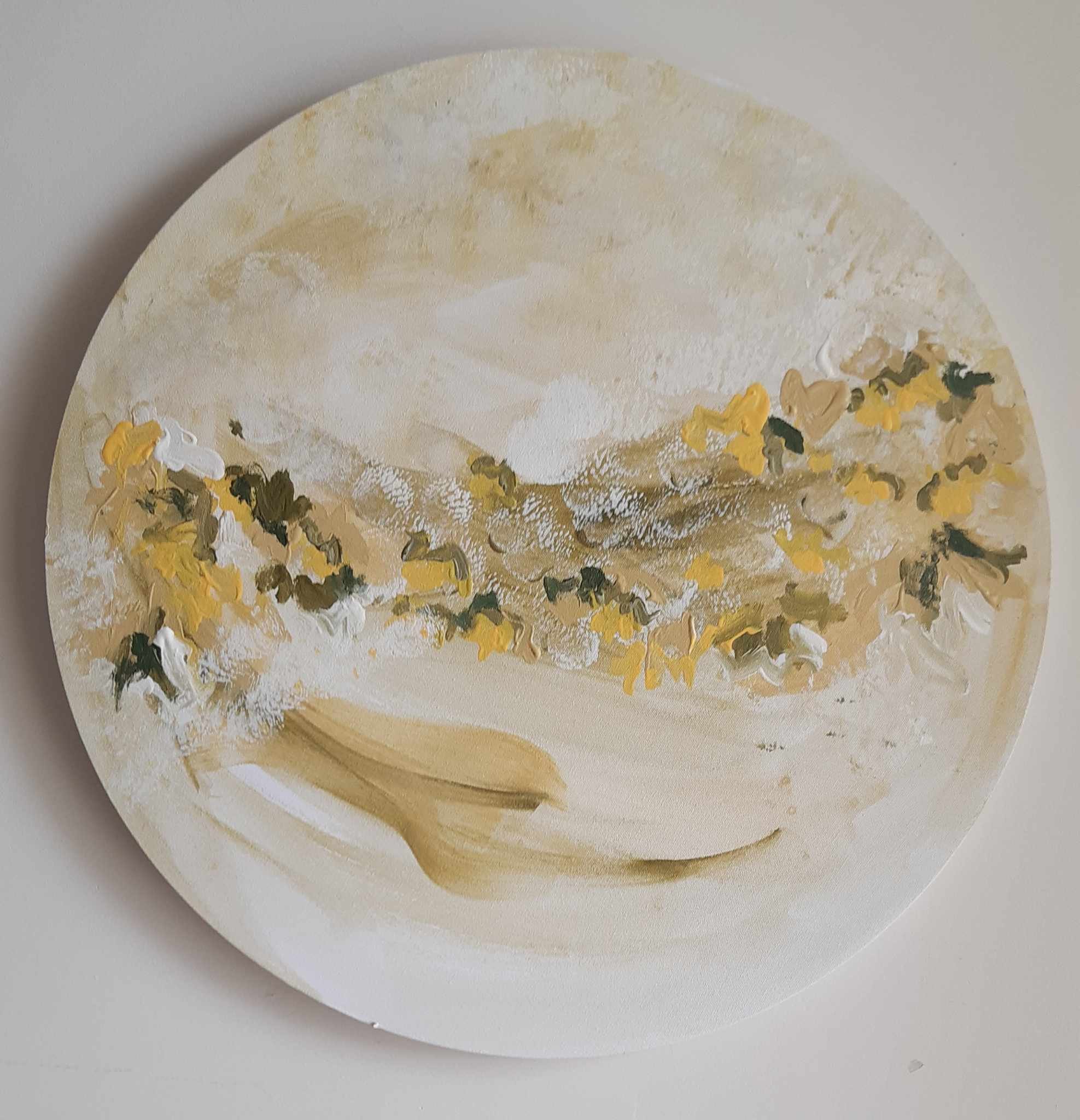 Close-up of a round, white and yellow marble-patterned plate with textured, painted floral design at the edges.