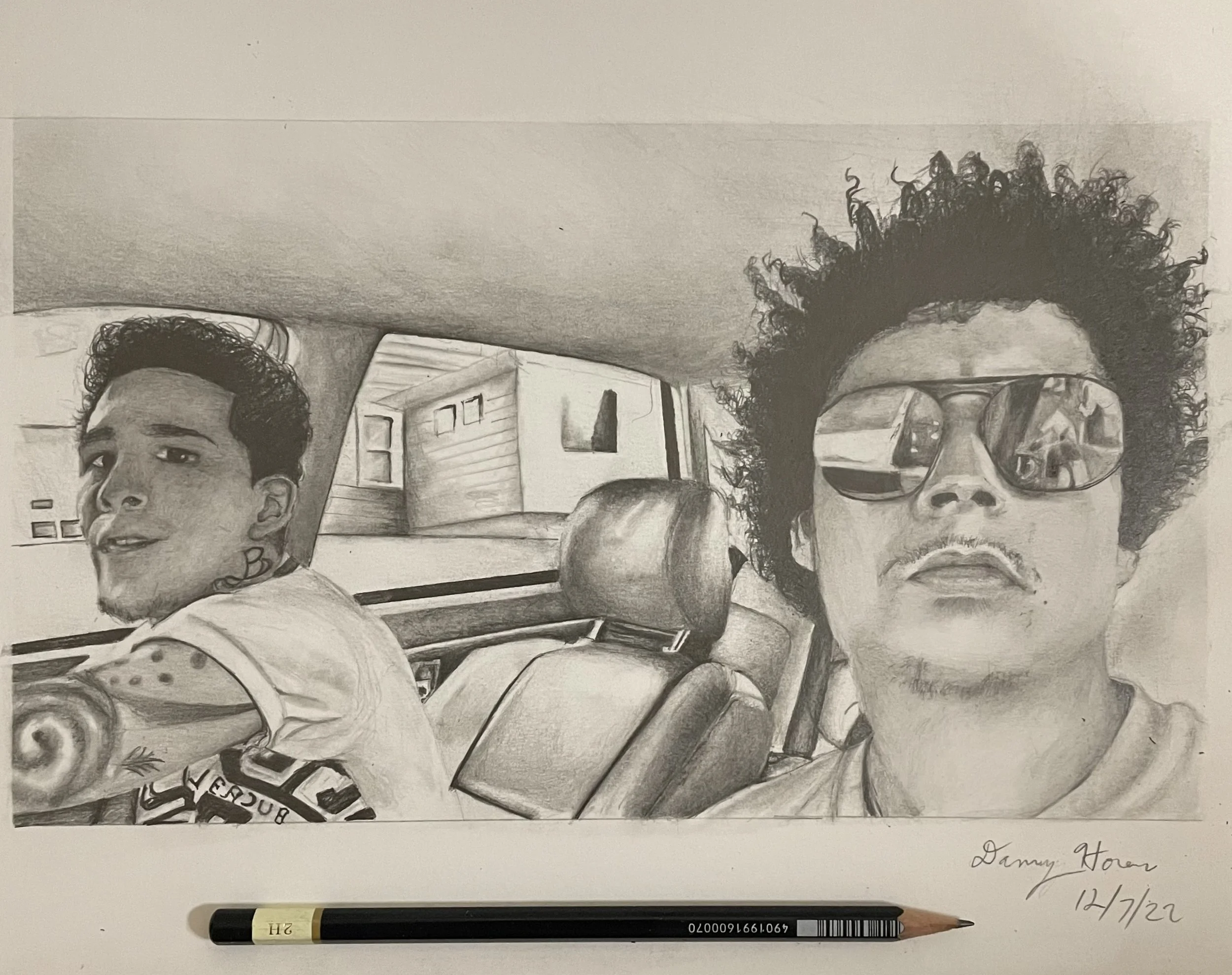 A graphite pencil drawing of two men sitting inside a car, with the man on the right wearing sunglasses and sporting curly hair, and the man on the left looking to the side. The drawing includes the car interior and a view of houses through the windows. Signature and date at the bottom right.