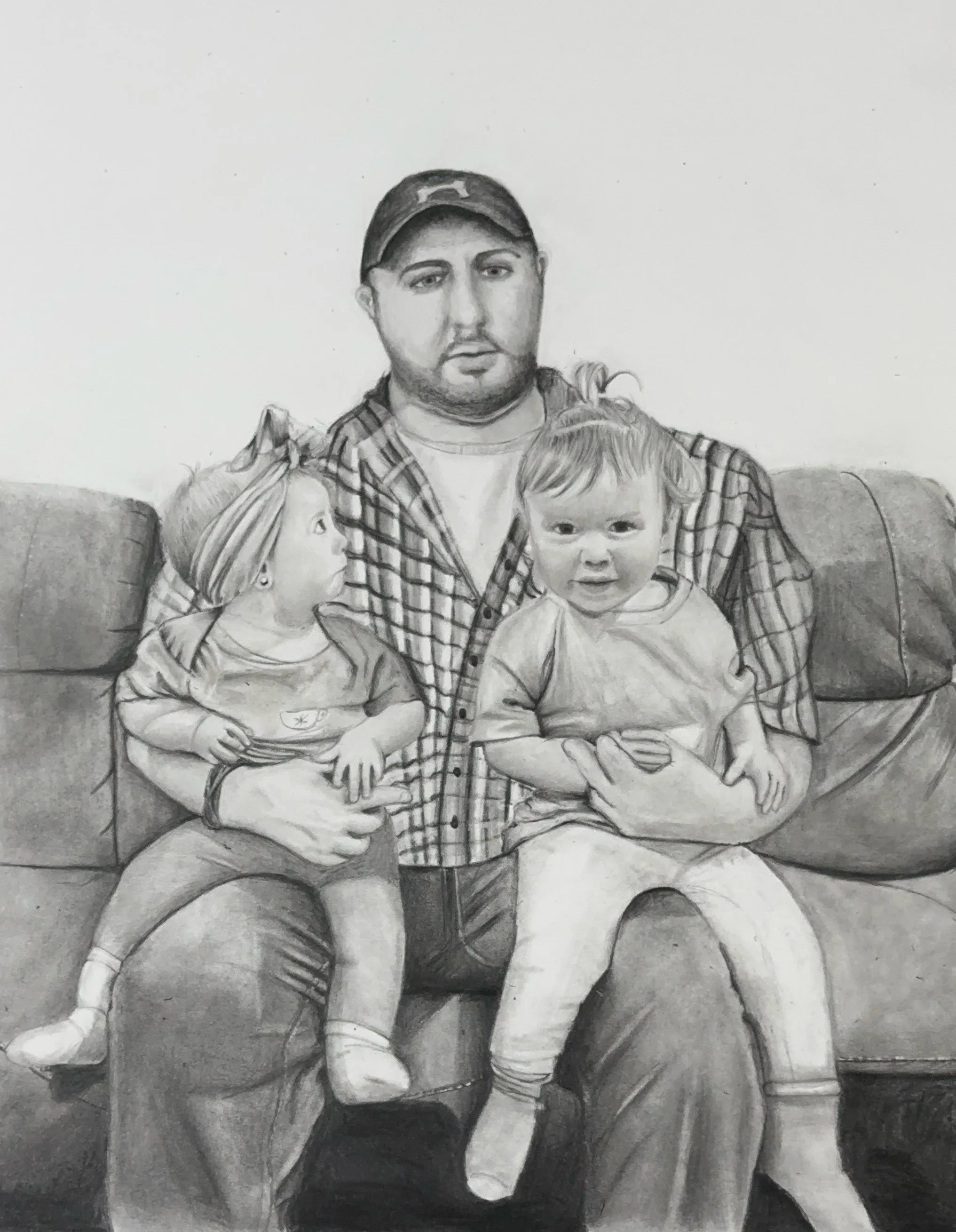 A black and white pencil drawing of a man and two young children sitting on a sofa. The man, wearing a baseball cap and plaid shirt, has his arms around the children, who are on his lap.