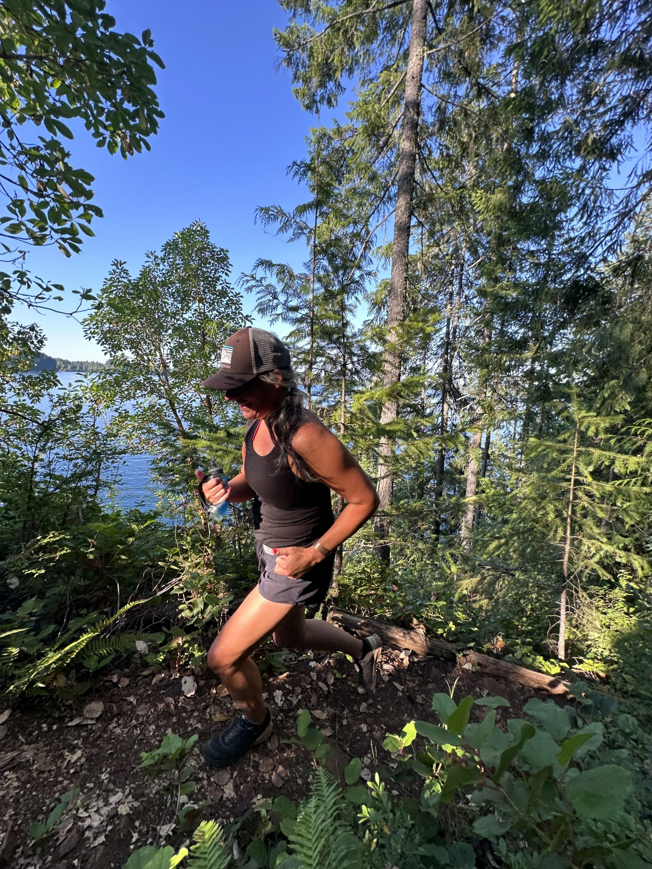 Coach Rhonda Teramura trail running through forest at Comox Lake